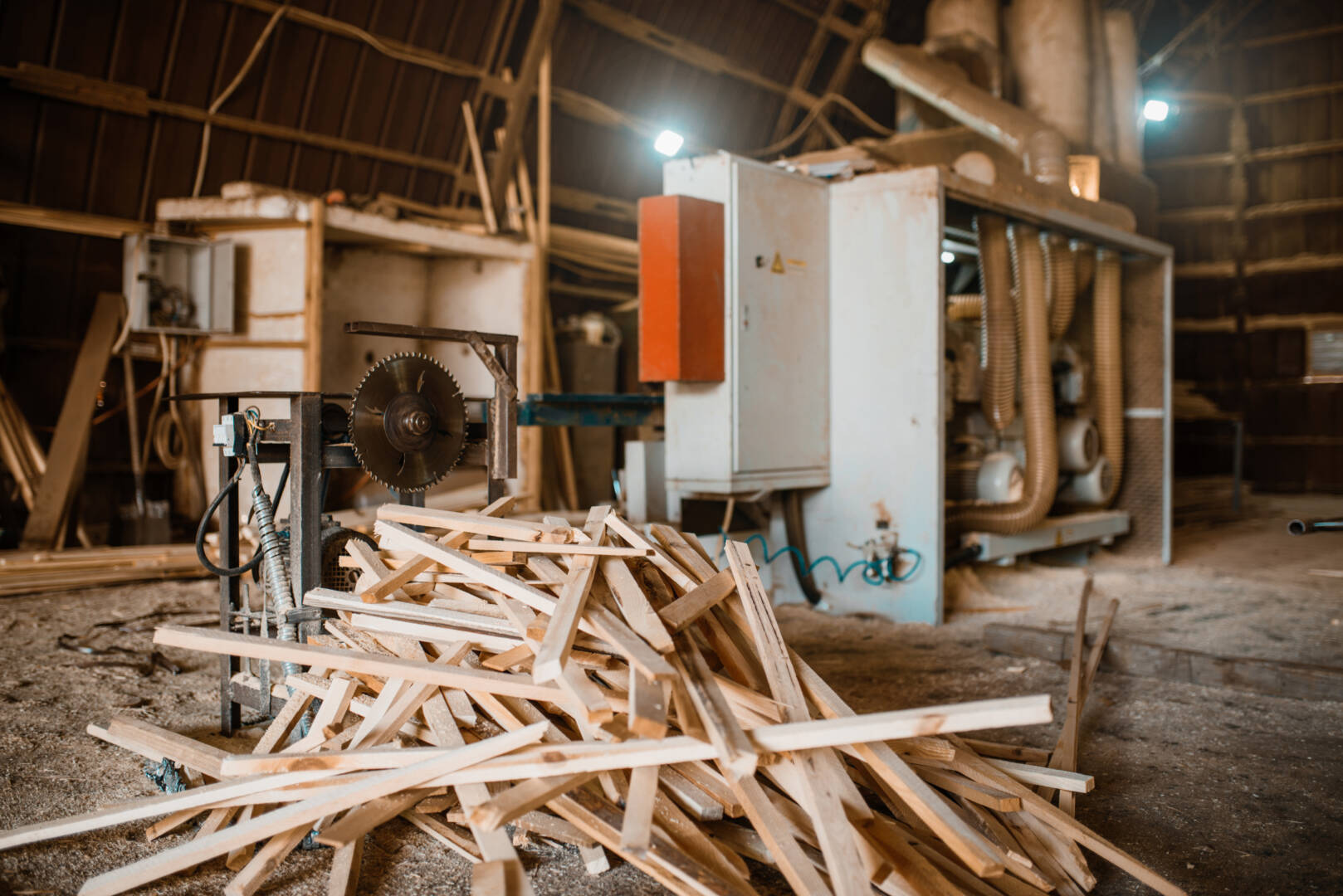 Stack of boards near woodworking machine, sawmill